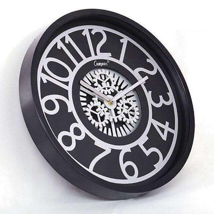 Väggklocka med synliga kugghjul i mitten