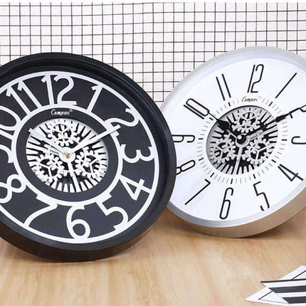 Väggklocka med synliga kugghjul i mitten