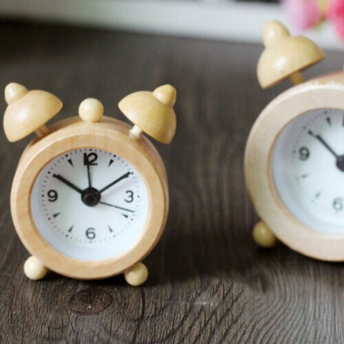 Liten rund väckarklocka i ljust trä